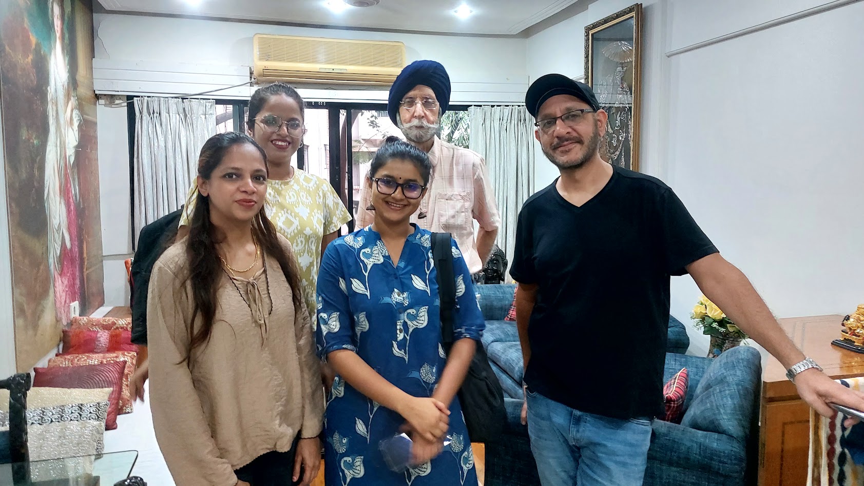 The author, his father, and the PalCare team of five standing together in the family's living room after the onboarding visit